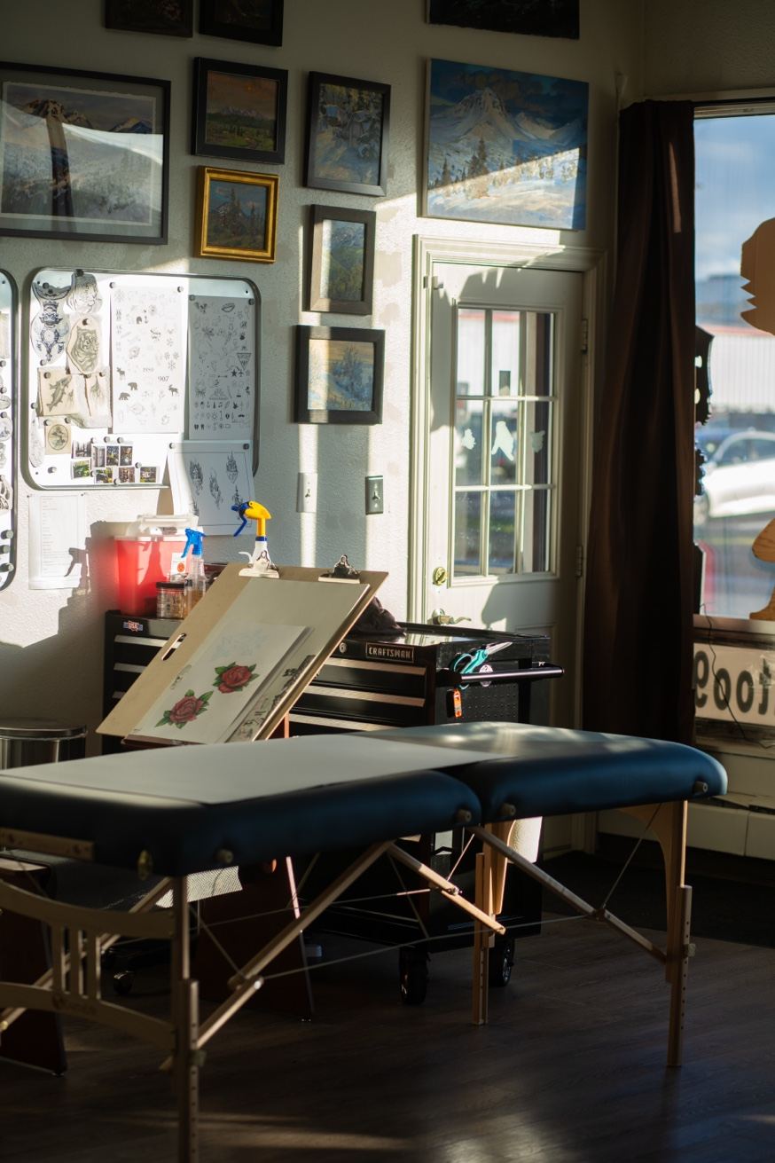 Cade Bennett tattoo station AK Tattoo Anchorage — Alaska art and flash sheets on the wall